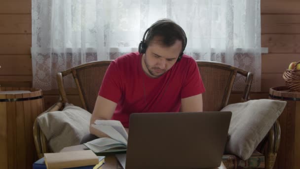 젊고 잘생긴 청년 이 집에서 랩탑 컴퓨터로 일하며 인터넷을 공부하고 있습니다. — 비디오