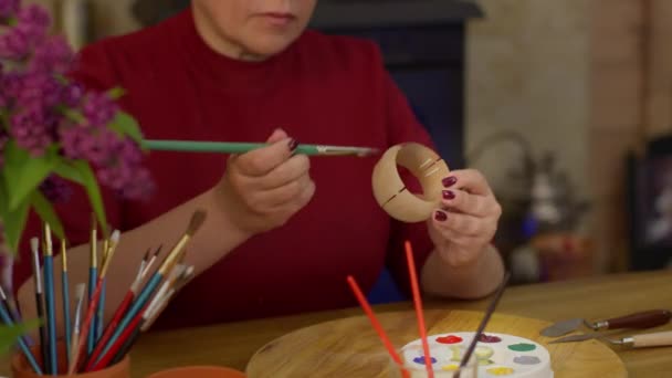 Gros plan Peinture d'artiste féminine sur pot en céramique argileuse, pinceaux et peintures sur table — Video