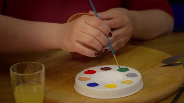 Cerca de hermosas pinturas de mujer en la pulsera de joyería de madera en el estudio de arte en casa — Vídeo de stock