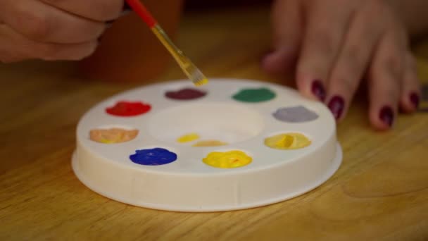 Close up beautiful woman paints on wooden jewelry bracelet in art home studio — Stock Video