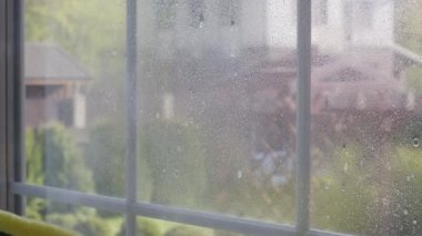 Yakın çekim pencereyi siliyor, evi temizliyor, tozları paçavrayla ovuyor.