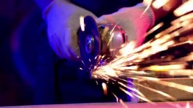 Metal kesme makinesinin parlak kıvılcımları, el işi.