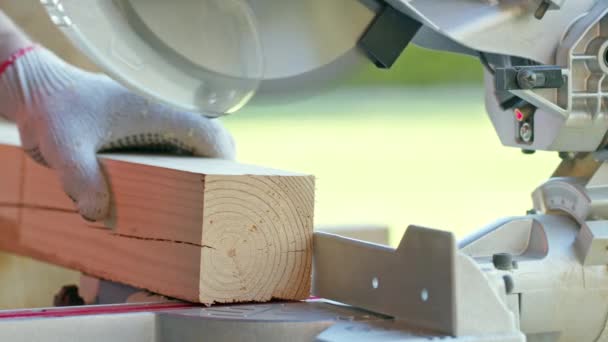 Cortar con precisión la pieza de madera en la sierra de mitra. pieza de corte cae bien — Vídeo de stock