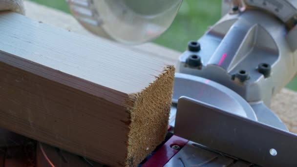 Проект саморобного дерев'яного працівника в рукавичках відрізав дерев'яний пост 4x4 на пиломатеріалі крупним планом — стокове відео