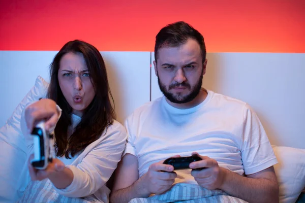 Casal de amantes apaixonadamente e emocionalmente jogar jogos de vídeo na cama — Fotografia de Stock
