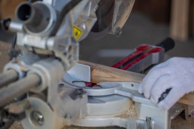 Dairesel testereyle kesmek için kırmızı lazer hattı ile tahta kiriş işaretleniyor.