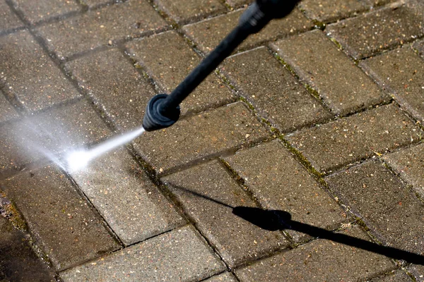 High-pressure washer cleaning concrete stones of garden line in country house — Stock Photo, Image