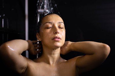 Genç, güzel bir kadın, gözleri kapalı duş alıyor, güzellik, kişisel bakım alıyor.