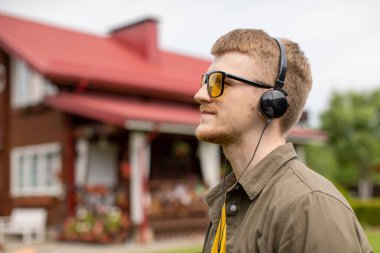 Sarı gözlüklü sakallı adam internette psikolojik eğitim dinliyor.