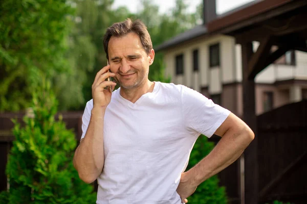 Mutlu orta yaşlı adam akıllı telefonla konuşuyor, dışarıda gülümseyen adam.