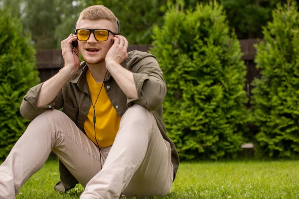 Bärtiger Typ, der Musik über Kopfhörer hört und fröhlich mit geschlossenen Augen singt — Stockfoto