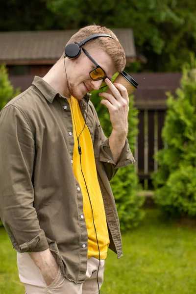 Bearded guy thoughtfully listening to music online through headphones — Stock Photo, Image