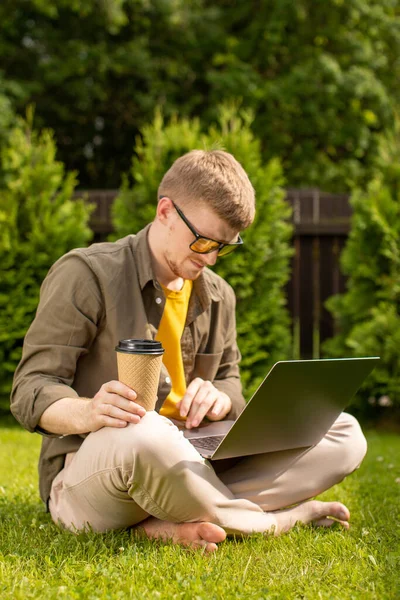 若い千年紀の男性学生は屋外で無線LAN接続を使用して宿題を作る — ストック写真