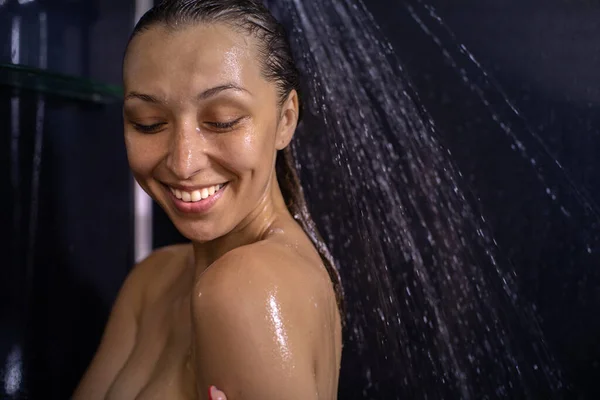 Sensual portrait of young happy sexy naked woman taking shower in black bathroom — Stock Photo, Image