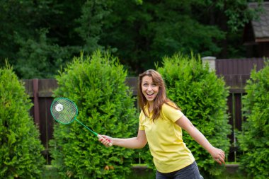 Dışarıda badminton oynayan hevesli genç bir kadın. Badminton oyuncusu iş başında