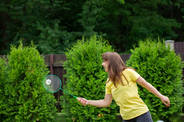 Atractiva joven sexy jugando bádminton con raqueta y volante — Foto de Stock