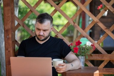 Zeki, yakışıklı iş adamı ev dışında dizüstü bilgisayarla çalışıyor.
