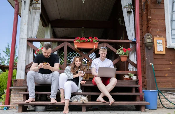 Amigos felices Pasa tiempo al aire libre en la terraza de la casa de madera con aparatos modernos — Foto de Stock