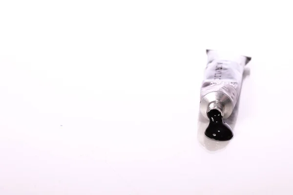 Tubo preto espremido de tinta acrílica isolada sobre fundo branco — Fotografia de Stock