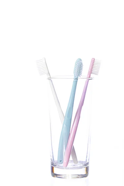 Three pastel shades Toothbrushes in glass isolated on white background — Stock Photo, Image