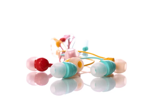 Bunch of colorful earphones isolated on white backdrop and mess of tangled wires — Stock Photo, Image