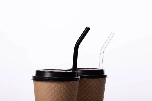 Zwei umweltfreundliche Kraft-Kaffeetassen mit Glashalmen auf weißem Hintergrund — Stockfoto