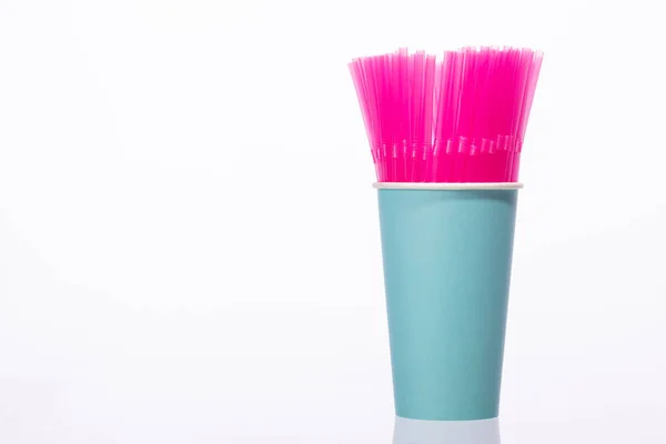 Bando de palhas de plástico rosa no espaço de cópia biodegradável azul copo de papel — Fotografia de Stock