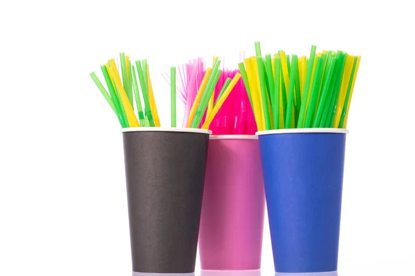 Pajitas para beber de plástico de colores en vasos desechables aislados sobre fondo blanco — Foto de Stock