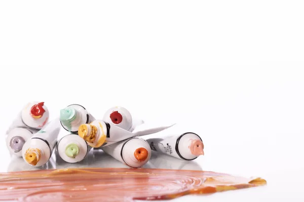 Pilha de tubos de tinta acrílica coloridos isolados no fundo branco. Workshop de arte — Fotografia de Stock