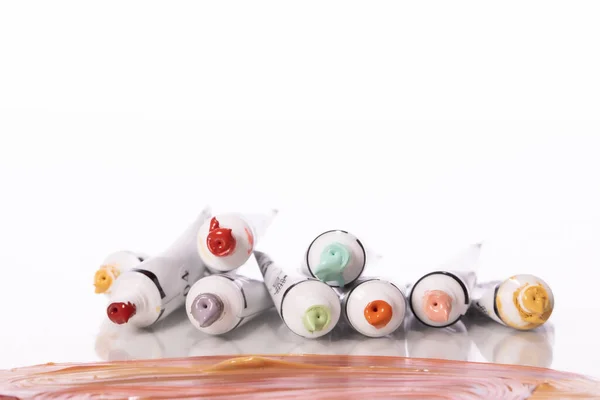Montón de coloridos tubos de pintura acrílica sobre fondo blanco. Manchas de pinturas al óleo — Foto de Stock