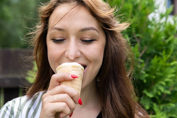 Outdoor close up portrait pretty woman eating ice cream smiling with closed eyes — Stock Photo, Image
