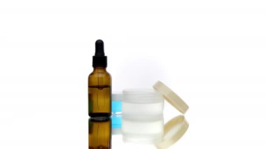 Kozmetik ürünleri, şeffaf jeller ve damlalarla dolu üç şişe ve kavanoz.