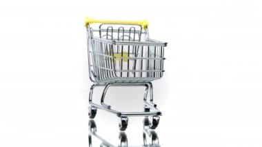 Beyaz arka planda izole edilmiş küçük boş alışveriş arabası dönüyor. E-ticaret