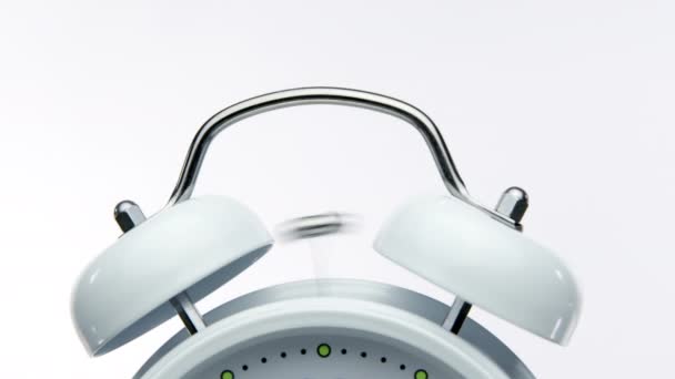 Close up bell of vintage white alarm clock triggers alarm on white background — Stock Video