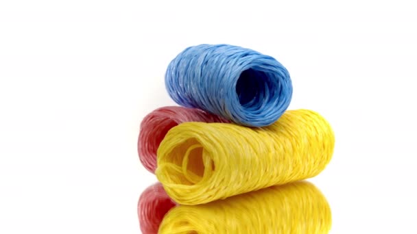 Tre nystan av färgglada garnblå, gul och rosa färg spinning på vit — Stockvideo