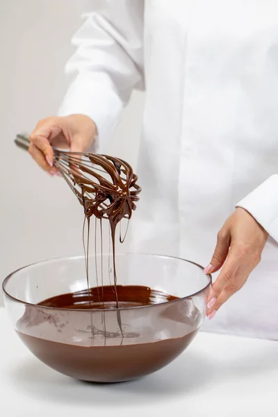 Pasticceria frullando cioccolato belga fuso in ciotola di vetro utilizzando frusta filo — Foto Stock