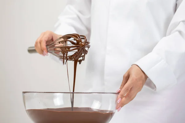 Glatte geschmolzene Milchschokolade mit Schneebesen in einer Glasschüssel verrühren. Nahaufnahme — Stockfoto