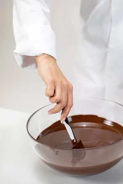 Primo piano chef femminile mescolando cioccolato fondente fuso isolato su sfondo bianco — Foto Stock