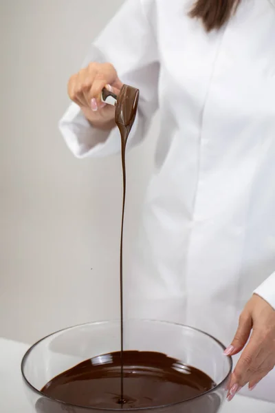 Cioccolato svizzero caldo fuso cade dalla spatola in ciotola di vetro preparare il cioccolato — Foto Stock