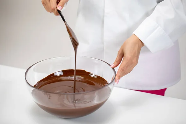 Chocolatier mischt dunkle, geschmolzene belgische Schokolade in Glasschale zur Zubereitung von Trüffeln — Stockfoto