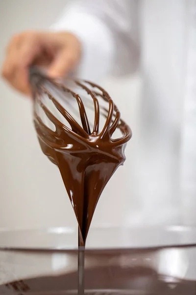 Primo piano versando gustoso cioccolato fondente su frusta, isolato sfondo bianco — Foto Stock