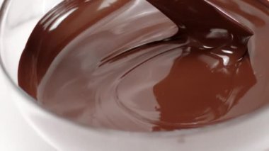 Silikon spatula, cam kasede erimiş çikolatayı karıştırır.