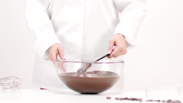 Closeup chef feminino misturando chocolate escuro derretido em tigela de vidro, câmera lenta — Vídeo de Stock