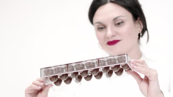 Atraente feminino chocolatier derramando chocolate escuro derretido de moldes slow mo — Vídeo de Stock