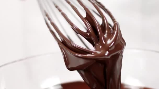 Chef tira batedor de chocolate derretido. fluxos de chocolate fluir para baixo lento mo — Vídeo de Stock