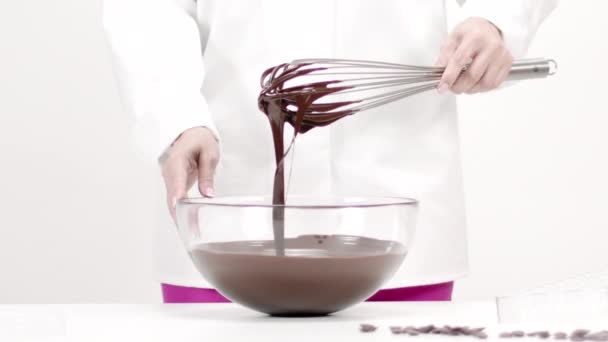 Closeup chocolatier gieten donker gesmolten chocolade op witte achtergrond, slow mo — Stockvideo