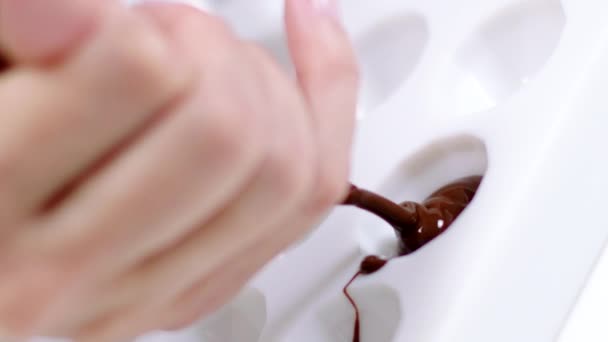 Closeup chocolatier vullen snoepgoed schimmel met gesmolten chocolade, slowmo — Stockvideo