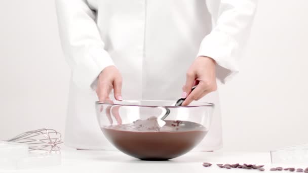 Chef Konditor Mischen geschmolzene Schokolade in Glasschüssel langsam mo auf weiß — Stockvideo