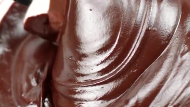 Nahaufnahme dunkle köstliche geschmolzene Schokolade mit Spachtel, Schokoladenwirbel umrühren — Stockvideo