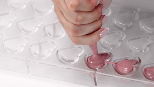 Zbliżenie wypełniające serce kształt cukierki pleśń z topionej rubinowej czekolady, zwolniony ruch — Wideo stockowe